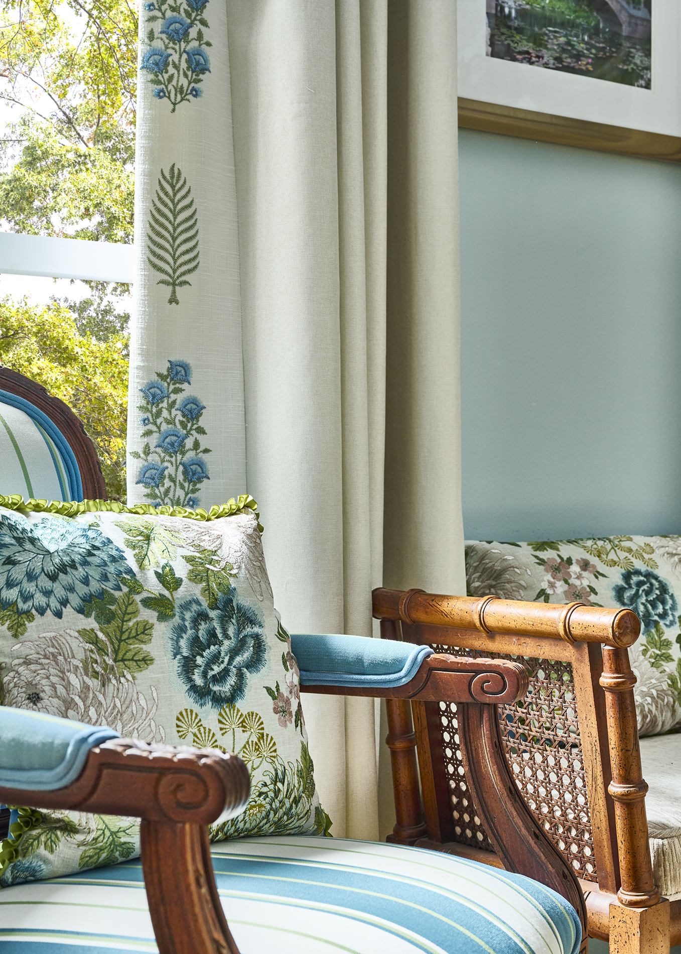 Layered floral upholstery and embroidered drapery in a collected Southern interior